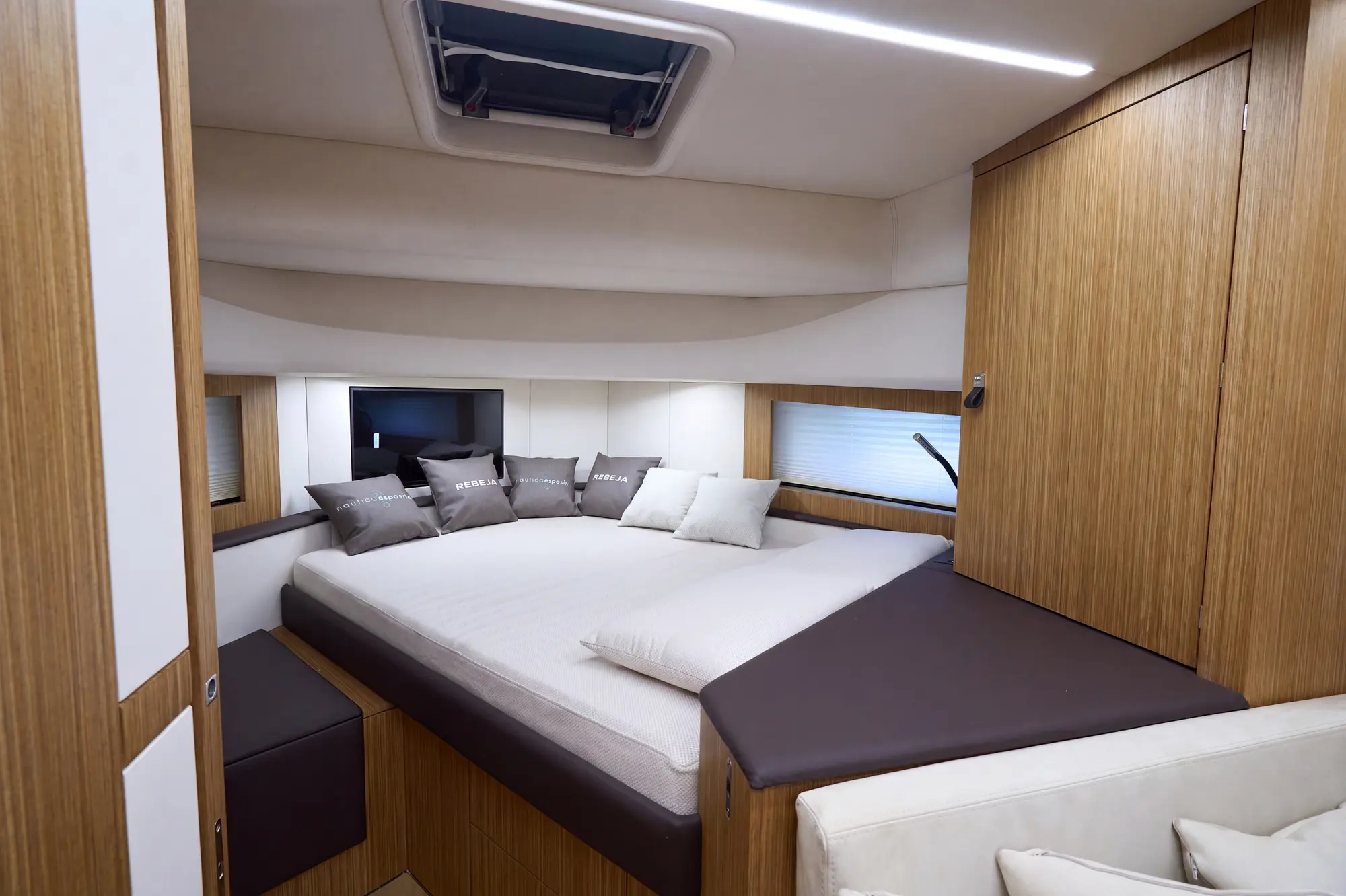 Cabina ospiti con letto, divanetto e rivestimenti in rovere chiaro