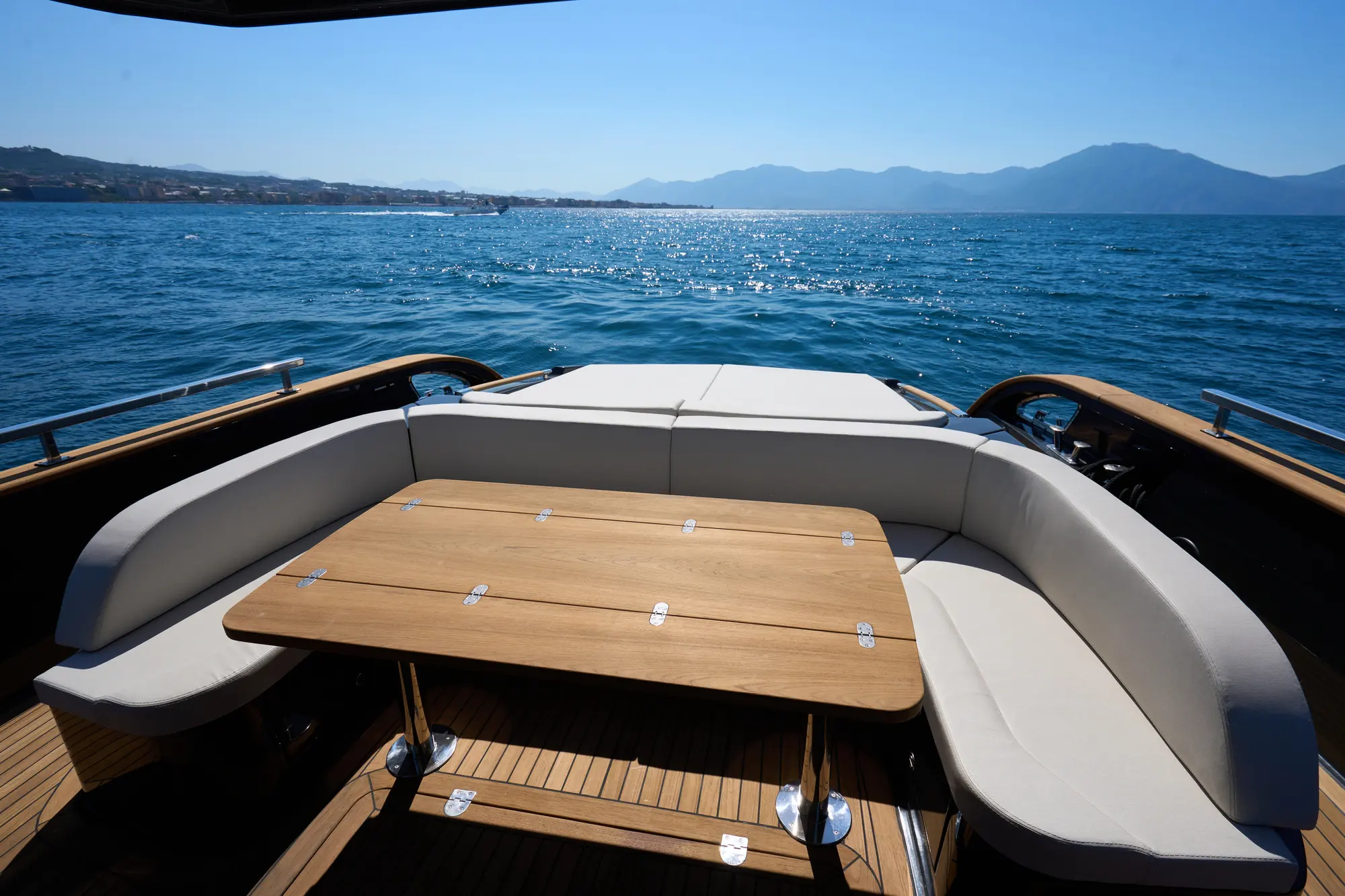 Pozzetto con divano a U e tavolo in teak affacciato sul mare