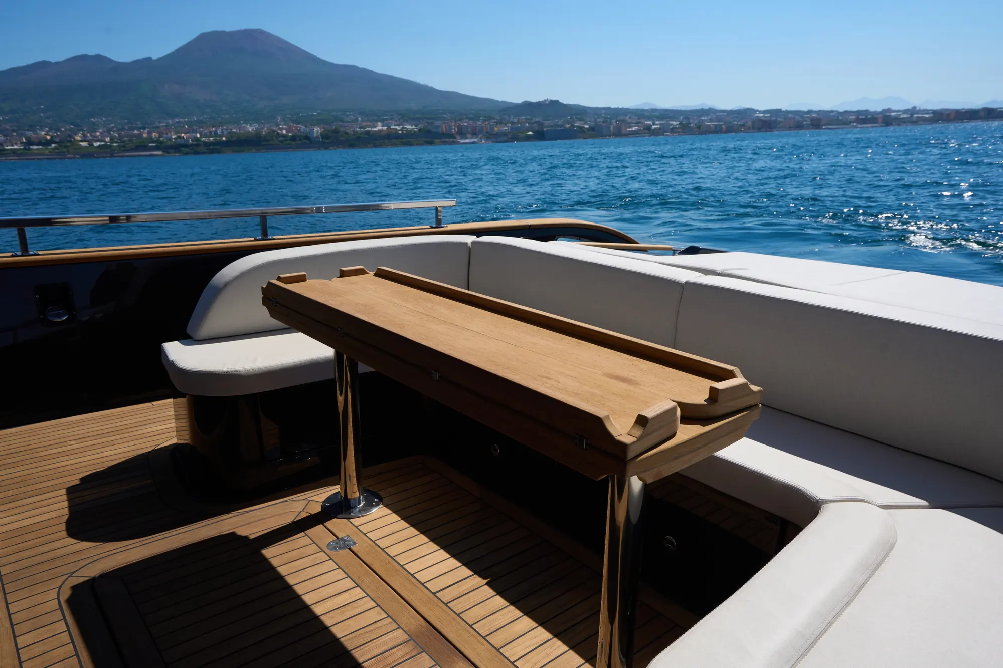 Tavolo in teak del pozzetto con il golfo e il Vesuvio sullo sfondo